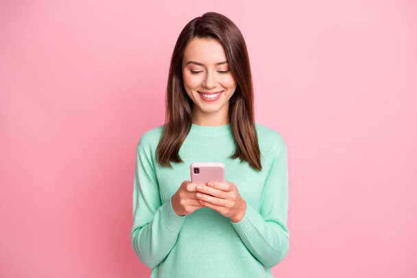 Photo of attractive person looking smartphone communicate teal pullover isolated on pink color background - Foto, immagini