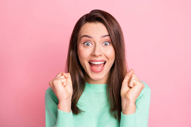 Photo portrait of happy shocked young brunette gesturing like winner shouting happily isolated on pastel pink color background - Zdjęcie, obraz