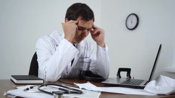 κουρασμένος γιατρός κάθεται στο γραφείο του - Πλάνα, βίντεο