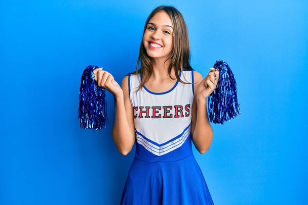 Young brunette woman wearing cheerleader uniform smiling with a happy and cool smile on face. showing teeth.  - Photo, Image