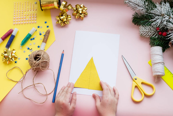 DIY käsite. Miten tehdä joulukortti. Uusi vuosi idea lapsille. Vaiheittaiset valokuva-ohjeet. Koristele kortti joulupuulla. Lasten luovuus. Poika tekee onnittelukortin. Vaihe 3 - Valokuva, kuva