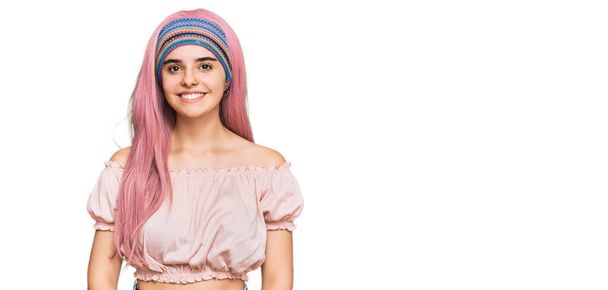 Mladá hispánská dívka s růžovými vlasy vypadá pozitivně a šťastně stojící a usmívá se s sebevědomým úsměvem ukazující zuby  - Fotografie, Obrázek