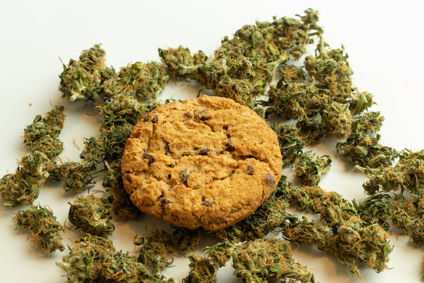 Galleta de cannabis en brotes de marihuana vista superior. Producto de cannabis comestible. - Foto, Imagen