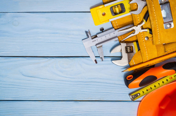 Kit d'outils de construction pour un constructeur dans un sac sur des planches en bois bleu également endroit pour la publicité - Photo, image