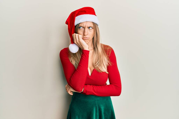 Mooie blanke vrouw dragen kerstmis kostuum en hoed denken kijken moe en verveeld met depressie problemen met gekruiste armen.  - Foto, afbeelding