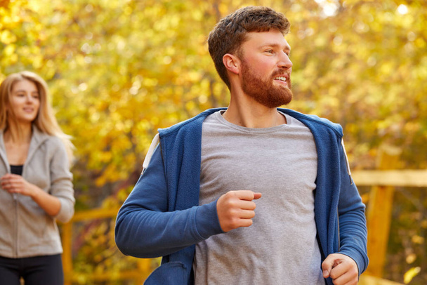 smiling man running in the park, enjoying healthy lifestyle - 写真・画像
