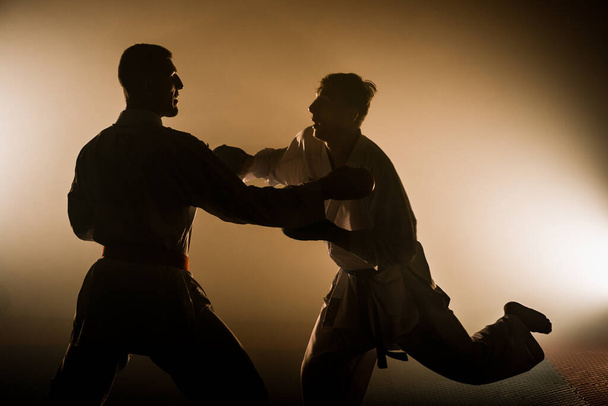 Ισχυρή φόρμα αθλητής, καράτε άνθρωπος ή μαχητής σε λευκό κιμονό, κοστούμι, με ζώνη που θέτουν σε στάση μάχης - Φωτογραφία, εικόνα
