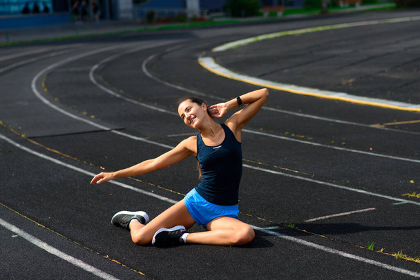 Атлетична бігунка біжить на спортивній трасі тренування її кардіо. Жінка біжить на змаганнях на літньому відкритому стадіоні
. - Фото, зображення