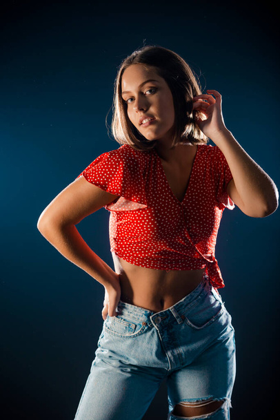 Studio body shot of a fashion female model posing in modern clothing isolated on dark background - Fotografie, Obrázek