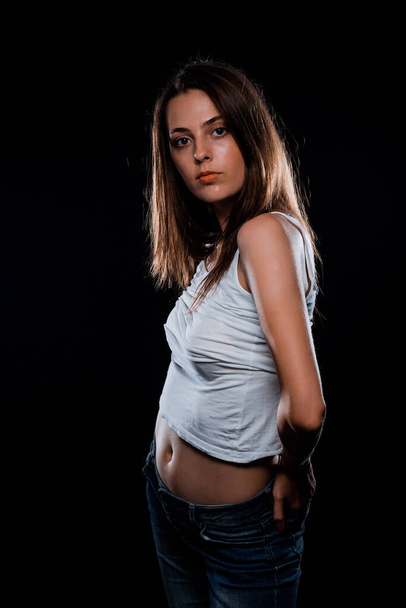 Portrait of an attractive stylish woman posing against dark background - Valokuva, kuva