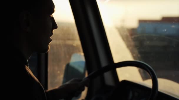 A young man is driving down a busy highway in his van and staring intently at the road. Side view from inside the cab - Πλάνα, βίντεο