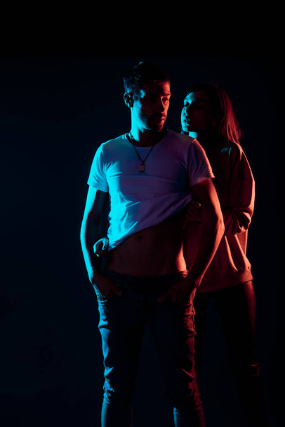 Attractive young man and woman posing against a black background - Photo, image