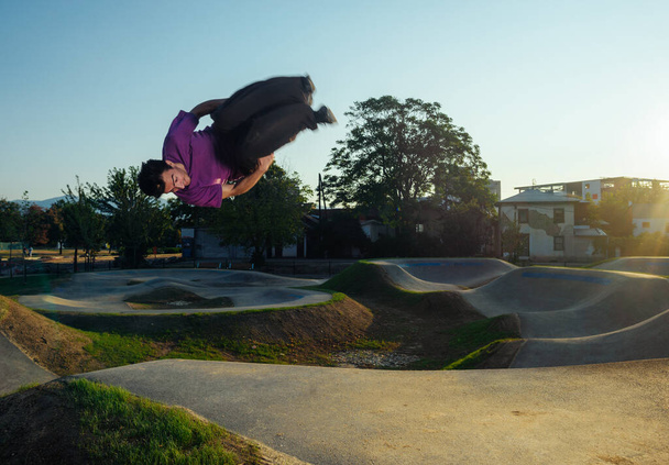 Nuori mies ilmassa suorittaessaan puoli flip klo skate park - Valokuva, kuva