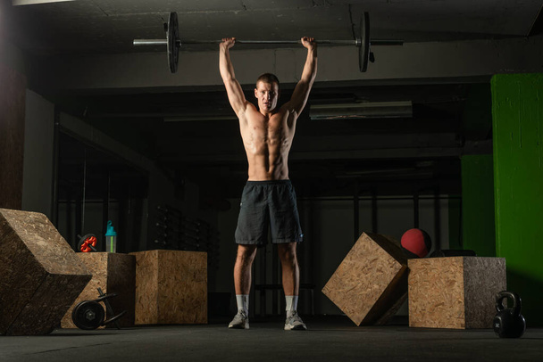 Πορτρέτο ενός αθλητή χωρίς πουκάμισο ετοιμάζεται για μια προπόνηση. - Φωτογραφία, εικόνα