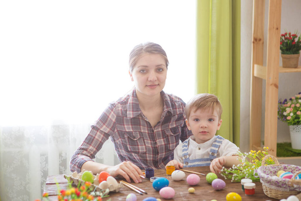 Mother and her son painting Easter eggs. Happy family preparing for Easter day. - Foto, immagini