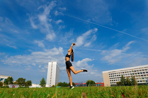 Атлетична бігунка біжить на спортивній трасі тренування її кардіо. Жінка біжить на змаганнях на літньому відкритому стадіоні
. - Фото, зображення