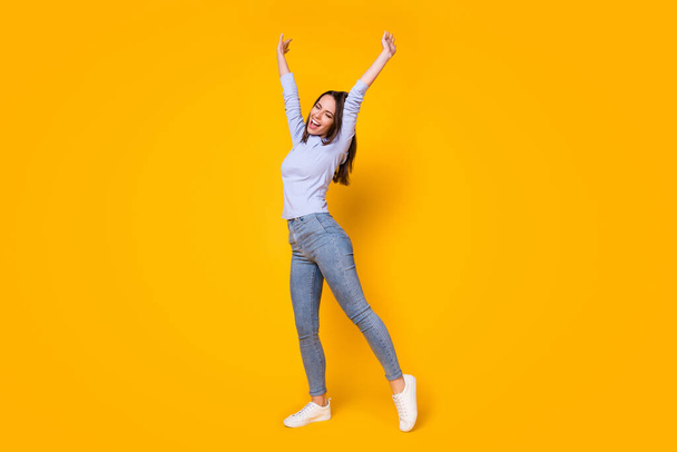 Full length body size view of her she attractive pretty carefree esctatic cheerful cheery girl having fun dancing rising hands up isolated bright vivid shine vibrant yellow color background - Фото, зображення