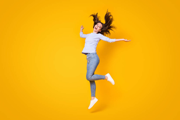 Full length body size view of her she attractive pretty thin cheerful cheery girl jumping throwing hair having fun good mood walking isolated bright vivid shine vibrant yellow color background - Фото, изображение