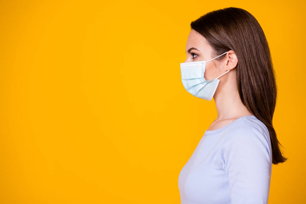 Close-up profile side view portrait of attractive confident healthy brown-haired girl wearing gauze mask sickness illness disease copy space isolated bright vivid shine vibrant yellow color background - Zdjęcie, obraz