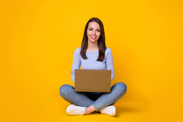 Full length photo of positive confident smart girl sit floor legs crossed work remote laptop texting typing report wear purple outfit isolated over bright shine color background - Fotoğraf, Görsel