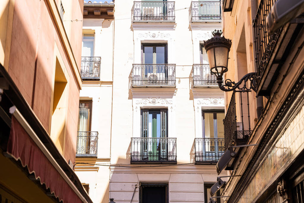 Old historic houses with windows, balconies and streetlight in Madrid - 写真・画像