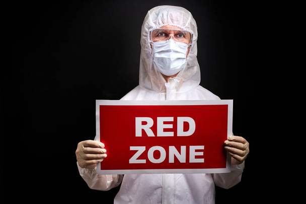 portrait of doctor male in protective medical suit holding tablet with RED ZONE inscription - Fotografie, Obrázek
