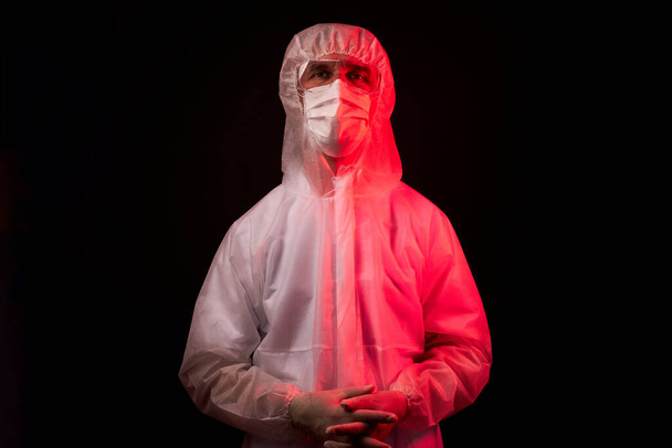 portrait of doctor man in protective mask or respirator for protection from virus disease over black background - Foto, Imagen