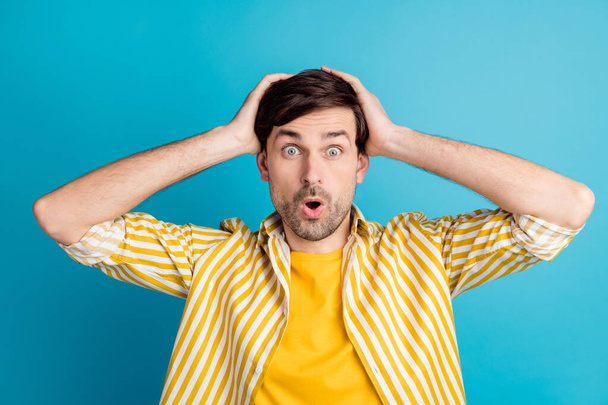Photo of astonished man hear season bargain novelty touch hands head scream wear striped yellow shirt isolated over blue color background - Φωτογραφία, εικόνα