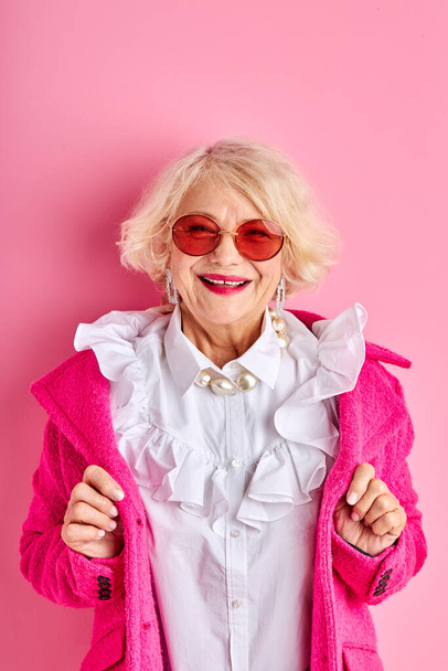 happy optimistic aged lady in blouse and coat smiles - 写真・画像