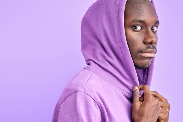 calm serious black male in casual purple pullover looks at camera - Photo, image