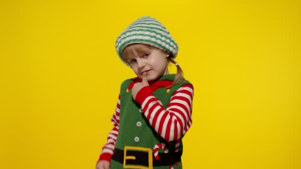 Lapsi tyttö lapsi joulun tonttu Santa apulainen puku näyttää peukalot ylös ele. Uusi vuosi loma - Materiaali, video
