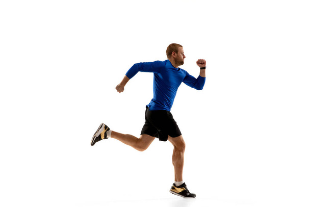 Caucasian professional runner, jogger training isolated on white studio background in fire - Foto, afbeelding
