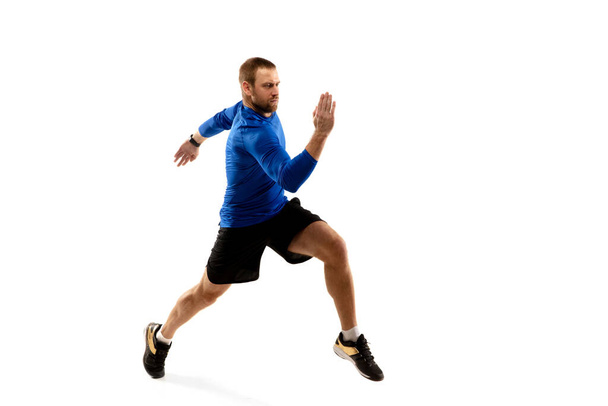 Caucasian professional runner, jogger training isolated on white studio background in fire - Photo, image