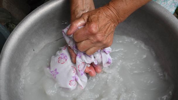 Handwash laundry by wrinkled hands of old woman - Photo, Image