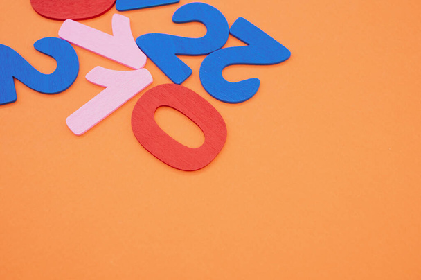 The colorful wooden numbers 2021 randomly positioned on the orange background - Fotoğraf, Görsel