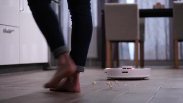 Staubsaugerroboter entfernt abgeworfenes Popcorn vom Boden - Filmmaterial, Video