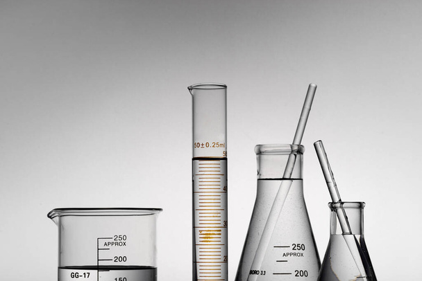 A closeup shot of transparent laboratory flasks, beakers, and tubes - 写真・画像