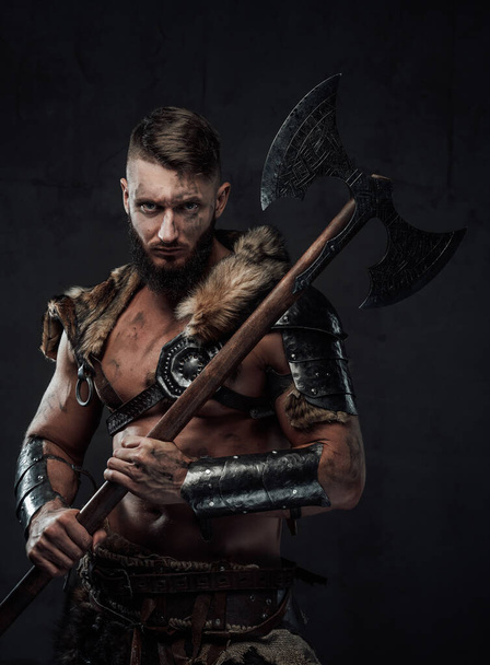 Luchador vikingo medieval sosteniendo un hacha enorme en su hombro - Foto, imagen