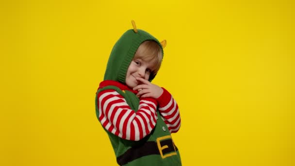 Kid tiener meisje in kerst elf Kerstman helper kostuum blaast lucht kussen op camera, knuffelen, omarmen - Video