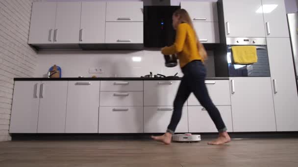 Nainen työskentelee kotona keittiö, kun robotti puhdistus - Materiaali, video