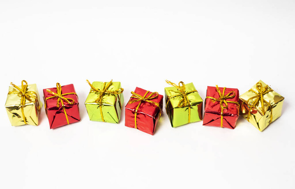 A top view of Christmas tree ornaments: colorful glittery gift boxes on a plain white background - Φωτογραφία, εικόνα
