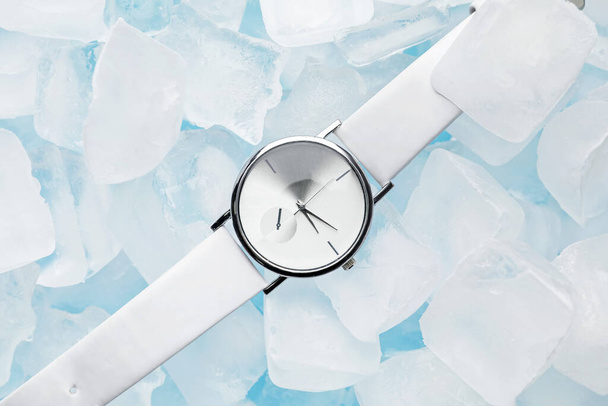 Wrist watch with ice cubes on color background - Photo, Image