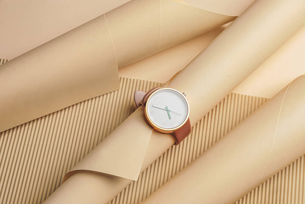 Наручний годинник з паперовими листами на кольоровому фоні
 - Фото, зображення