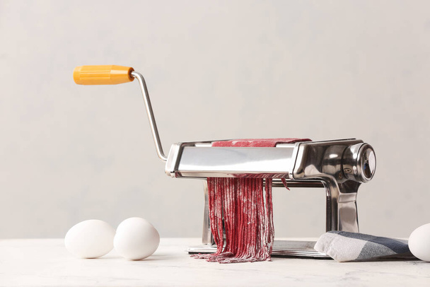 Pasta maker with dough on kitchen table - Foto, Imagem