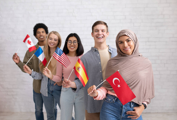 Modernes Austauschprogramm und Sprachenlernen. Glückliche junge internationale Studenten blicken in die Kamera - Foto, Bild