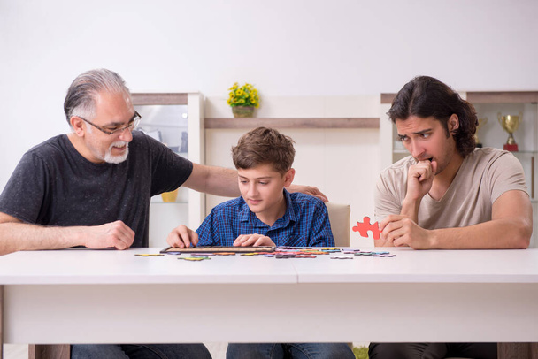 Три поколения семьи играют в головоломки - Фото, изображение