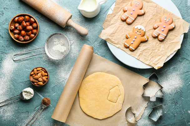Pâte fraîche pour biscuits au pain d'épice, découpeuses et ingrédients sur fond de couleur - Photo, image