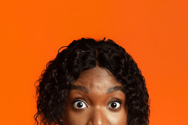 Крупный план черной женщины удивленные глаза, оранжевый фон - Фото, изображение