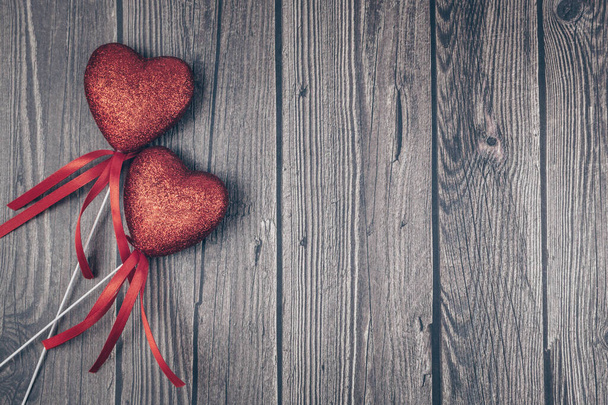 Un par de corazones de purpurina roja sobre fondo de madera oscura. Vista superior, plano, espacio de copia. Feliz tarjeta de San Valentín. Concepto de amor. - Foto, imagen