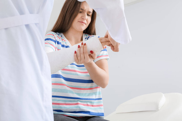 Jeune femme avec le bras cassé visite médecin à la clinique - Photo, image